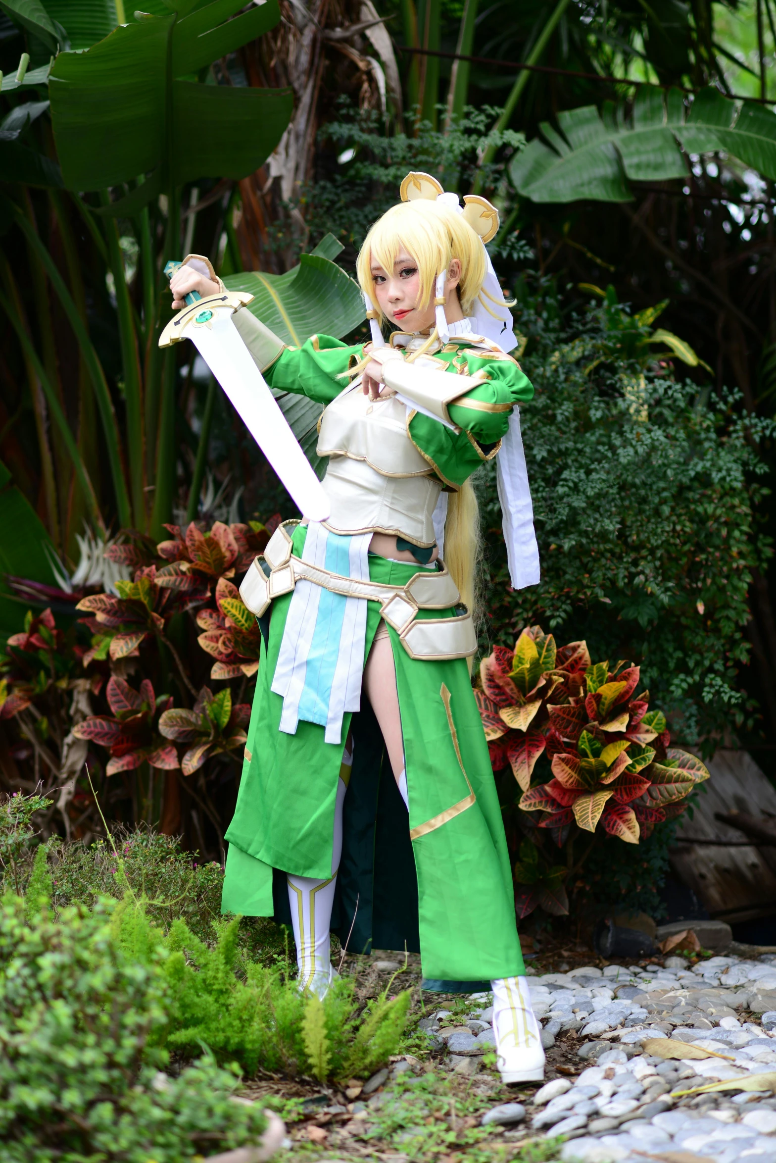 a woman in green cosplay standing with a sword