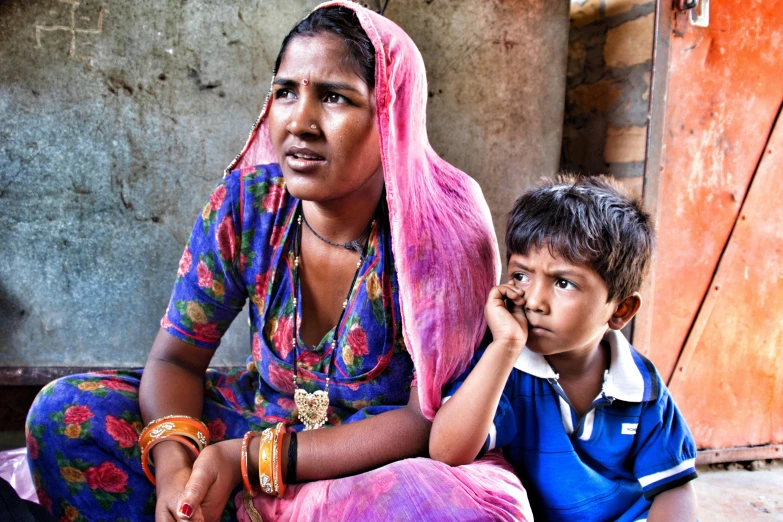 a little boy and woman that are sitting next to each other