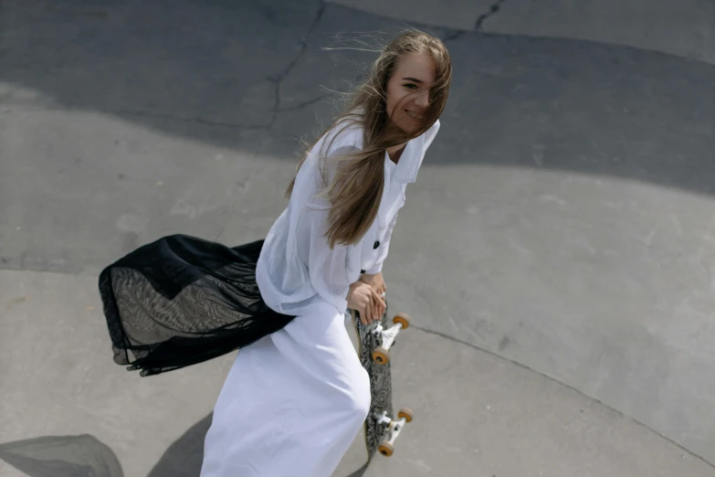 a female skateboarder in white is skateboarding on the ramp