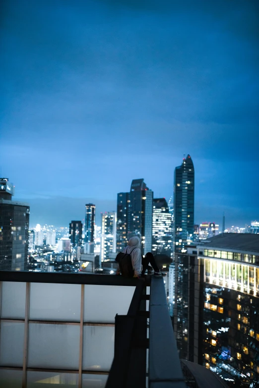 a person standing on top of a tall building at night