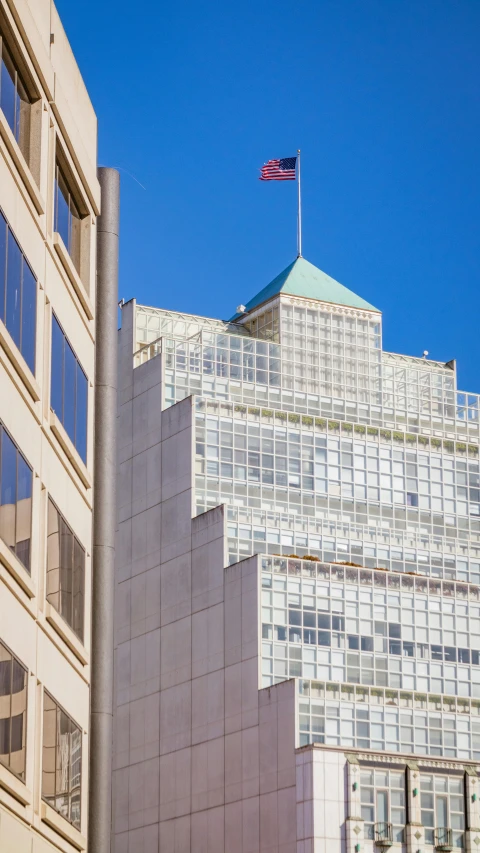 a building with a flag in front of a tall building