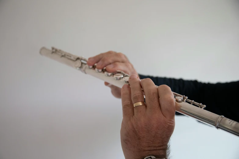 man in black shirt playing flute with fingers