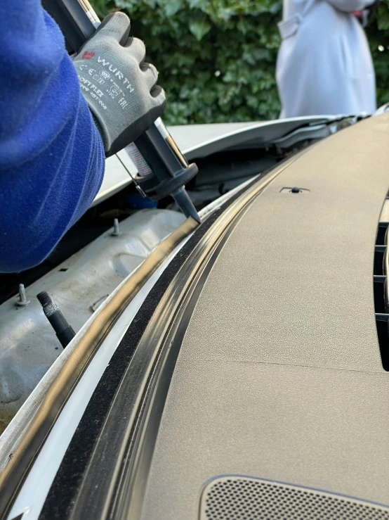 a person working on the hood of a car