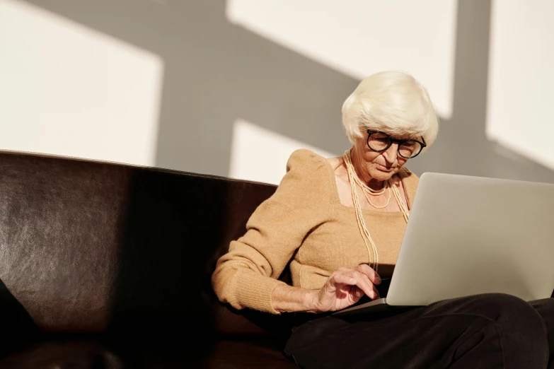 a very older lady looking at her laptop