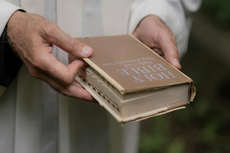 two different covers of a book being held in one hand