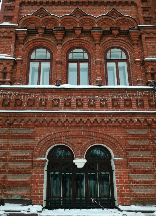 there are three large doors with windows on the side of a building