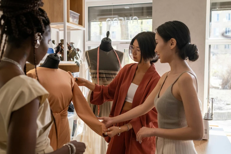 two women shaking hands in a room filled with mannequins