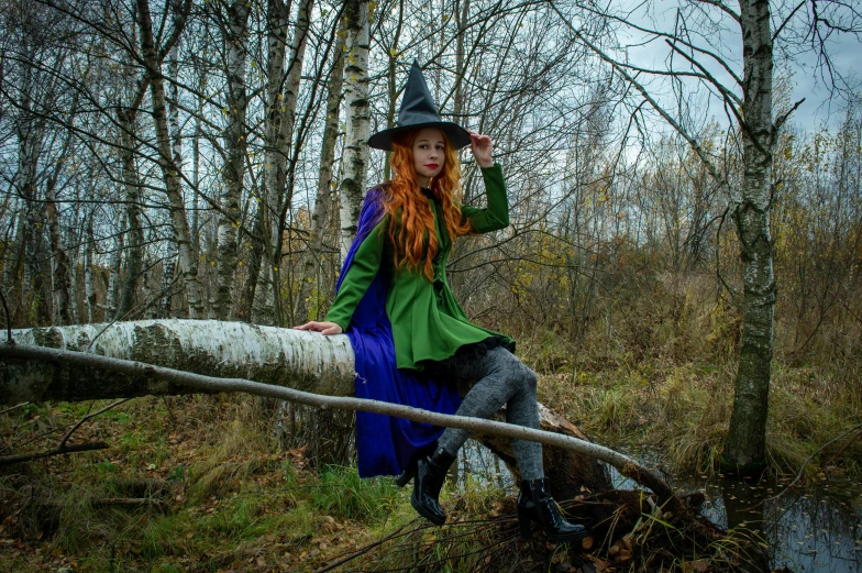 a woman sitting on a log in the woods