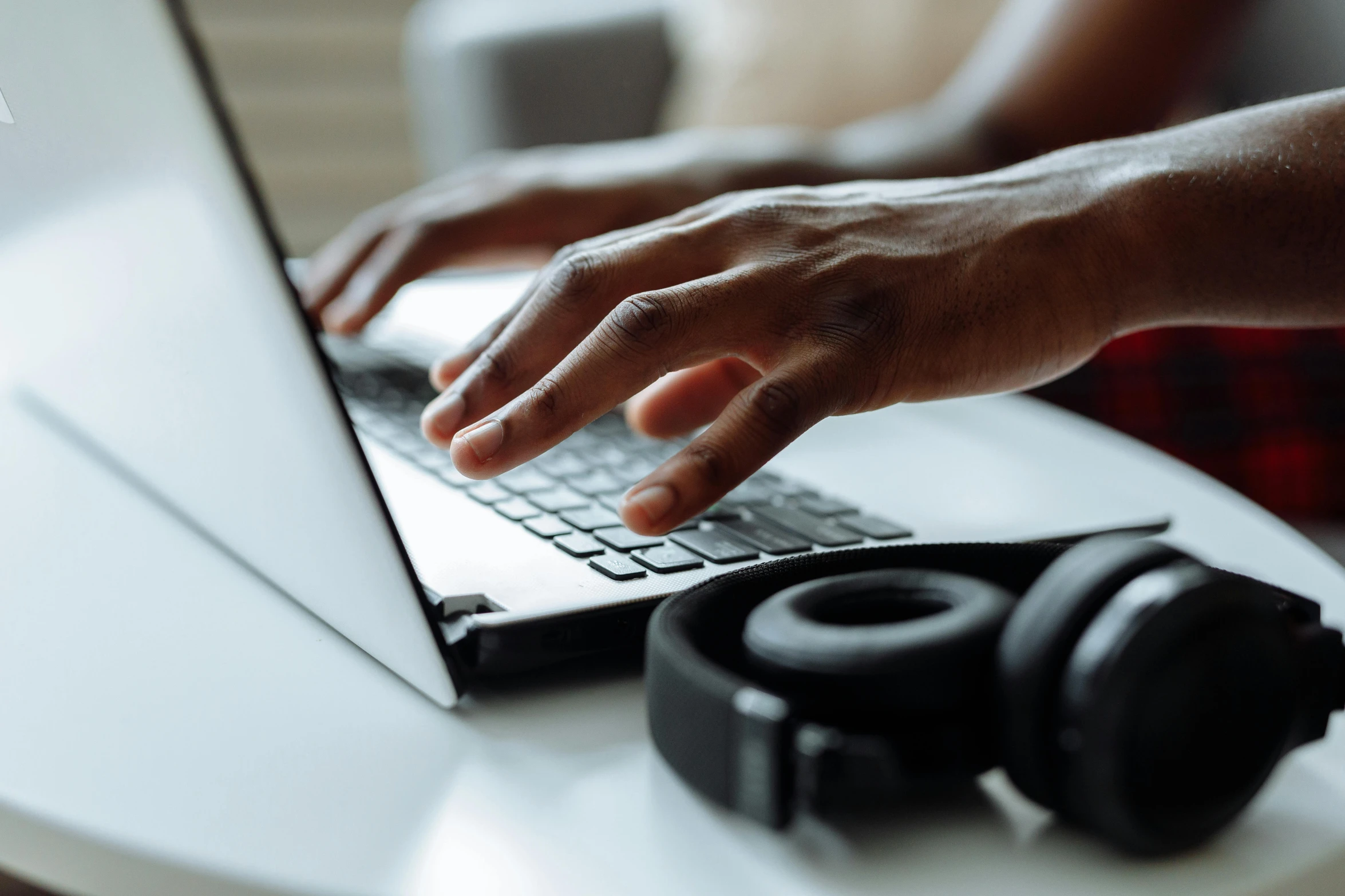 someone typing on a laptop while the person is holding it