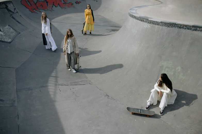 a group of girls riding skateboards down the side of a ramp