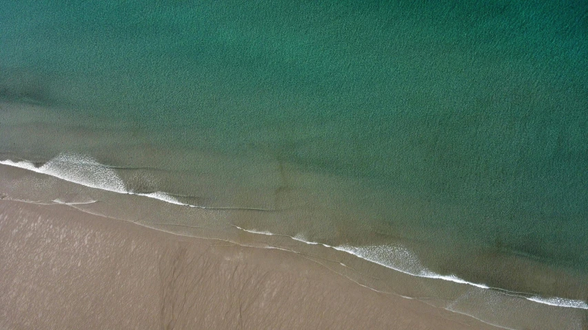 a beach with water that has a blue sky