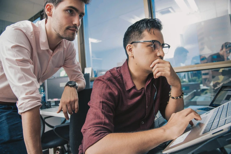 two men with laptops on their laps looking at each other