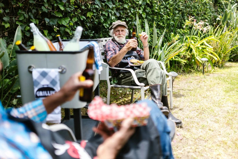 some men are sitting outside near some bushes