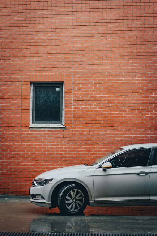 a silver car is parked in front of a red brick building