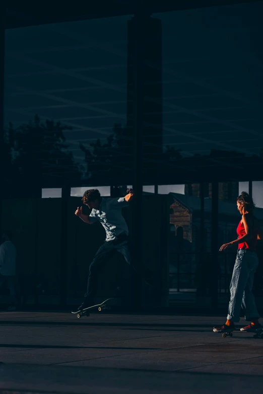 two men are playing with skateboards at night