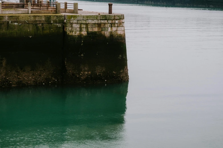 a person stands on a pier in a lake