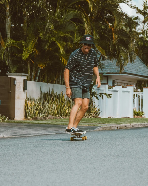 a man wearing blue shorts and an old man with a cap on riding his skateboard