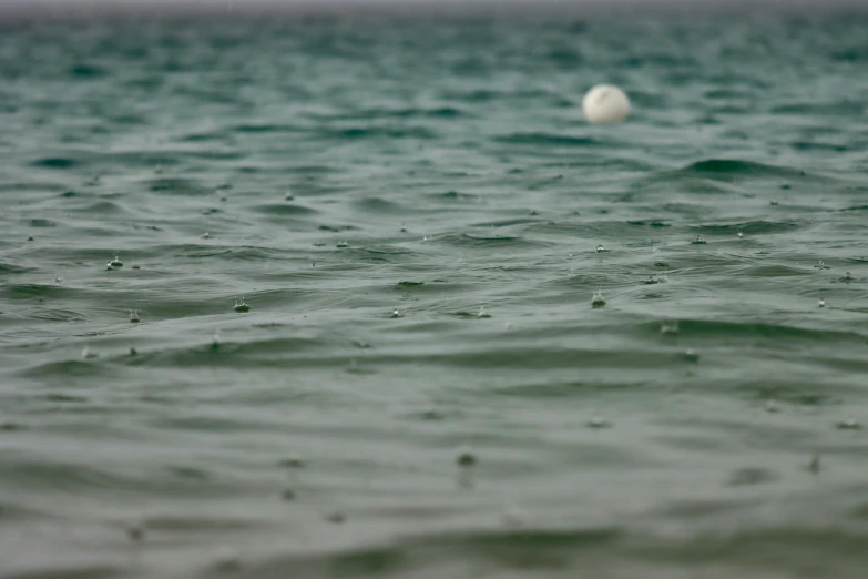 a small white ball floating over the ocean
