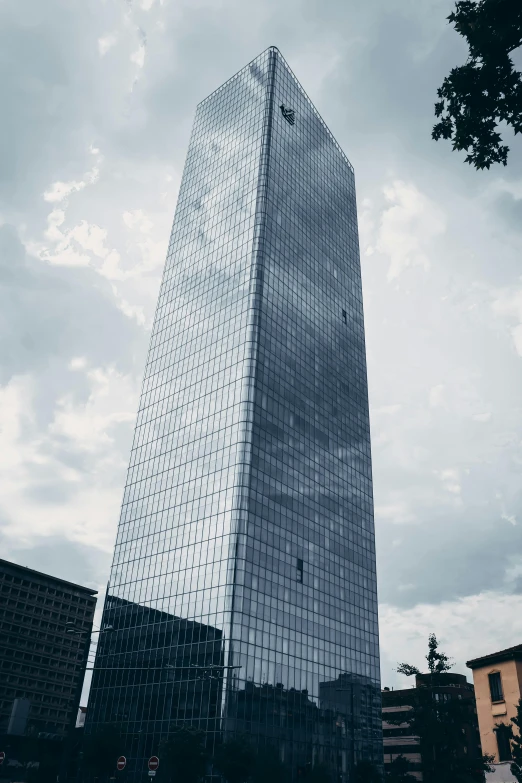 a tall skyscr in front of cloudy skies