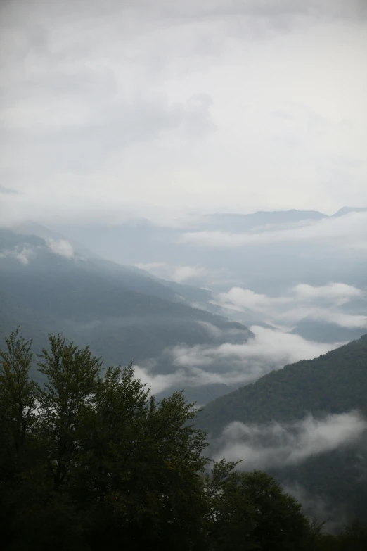 two distant mountains covered in a layer of fog