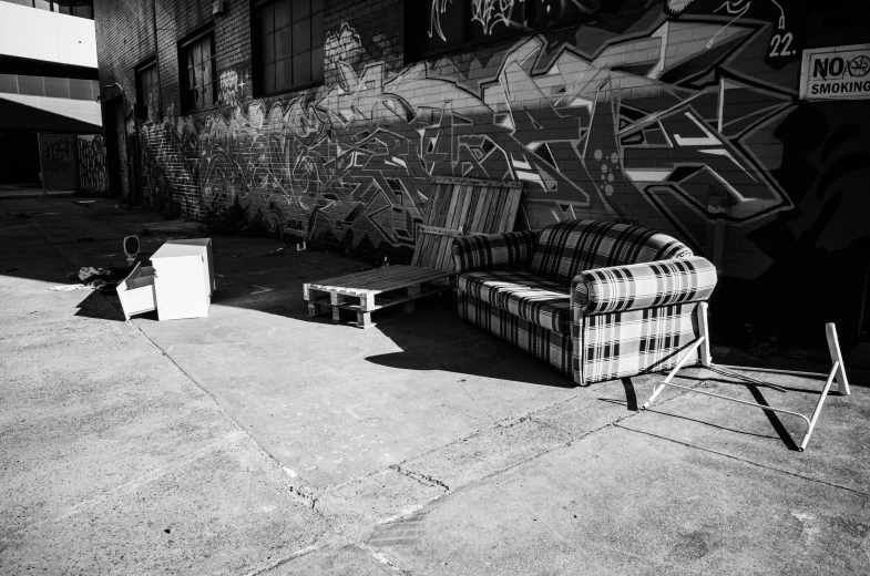 a street sign next to a very large black and white graffiti wall