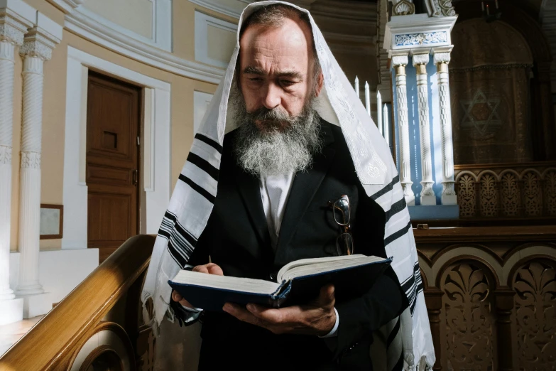 a man in black and white holds a book