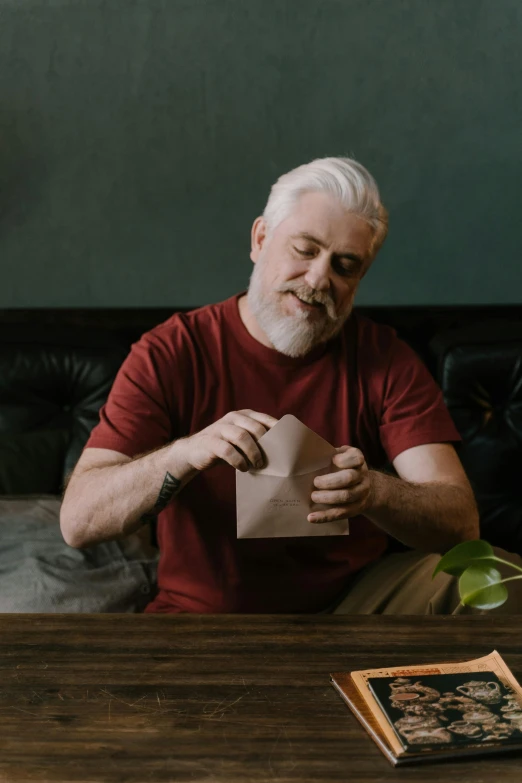 an old man is holding a piece of paper with a smile on it