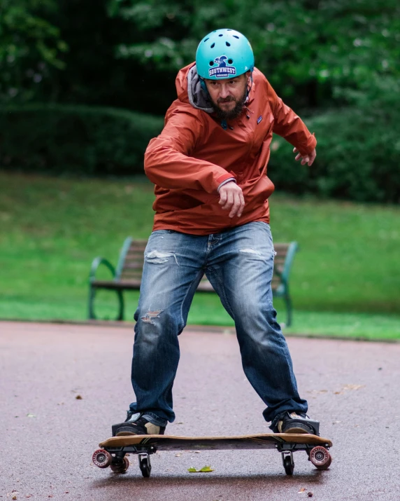 the man is wearing jeans and a blue helmet