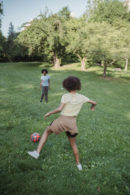 two young men playing ball in a park