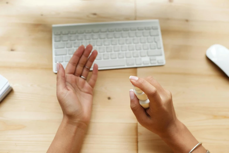 a person is holding their hand at a computer keyboard