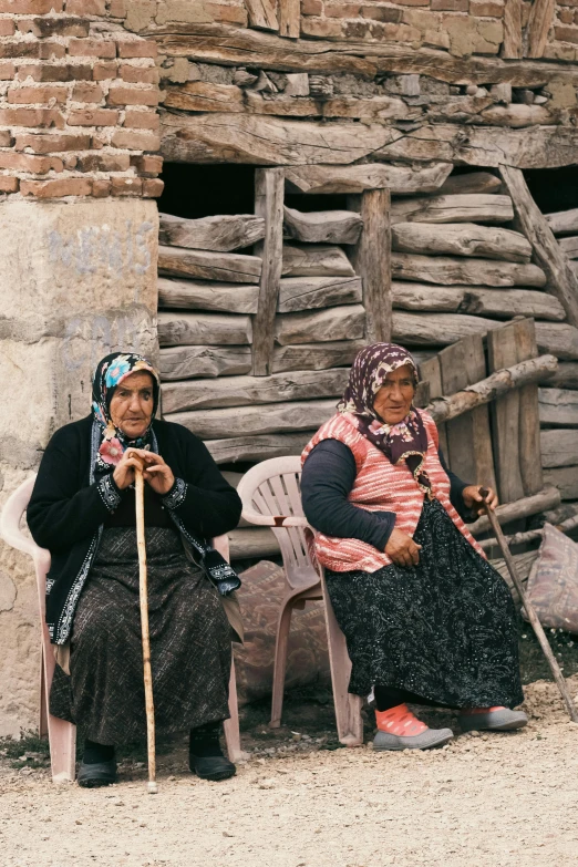 two women sitting next to each other on a field