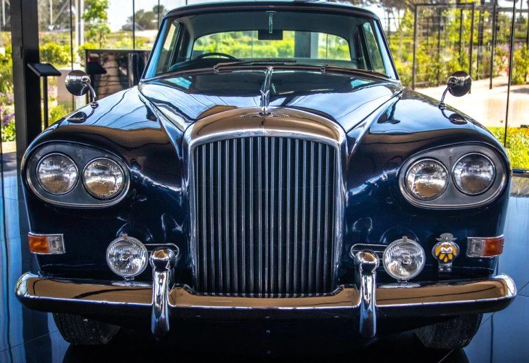 an old fashion looking blue car is parked in a garage