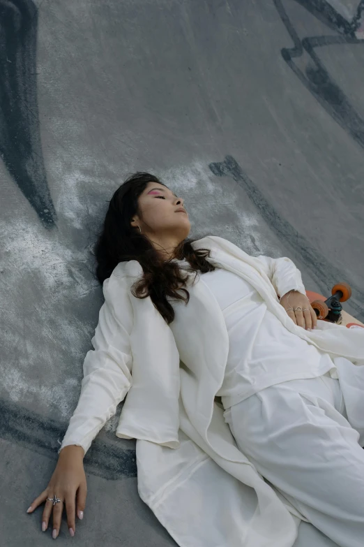 a woman laying on top of a cement slope