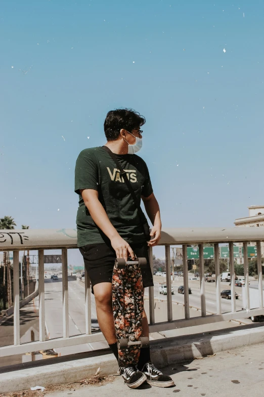 a man holding a skate board near a railing