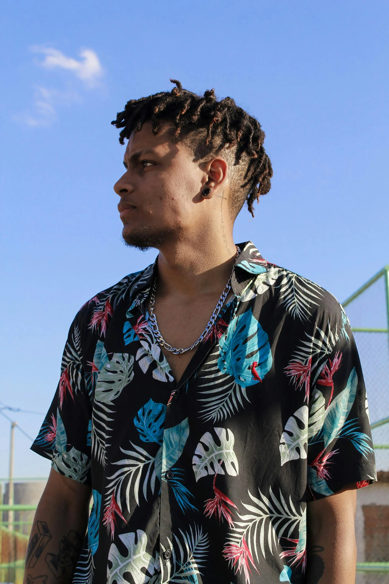 a young man with dreadlocks stands in a city