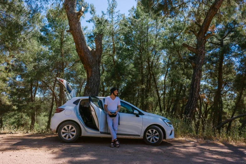 the guy sits in the car by the trees