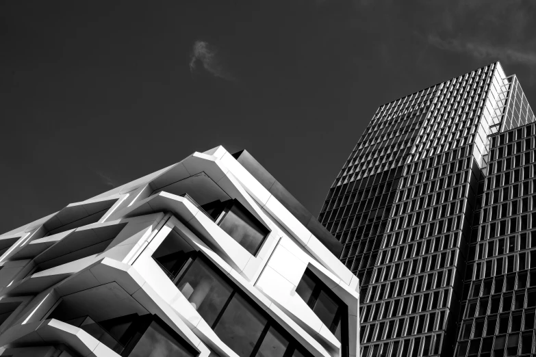 two tall buildings with large windows against a blue sky