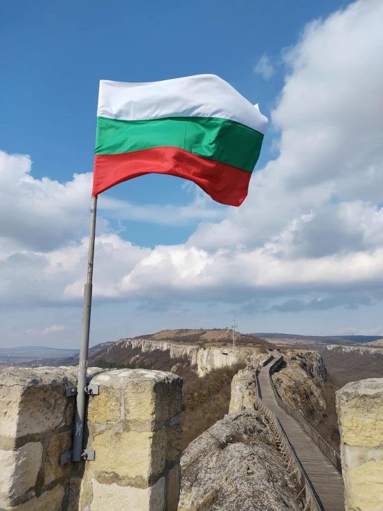 an indian flag flies on the side of a stone wall