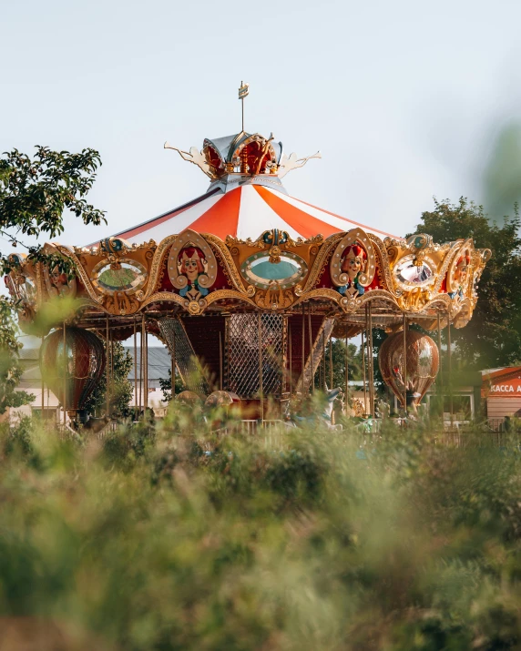 a carousel with red and yellow colors is seen from behind