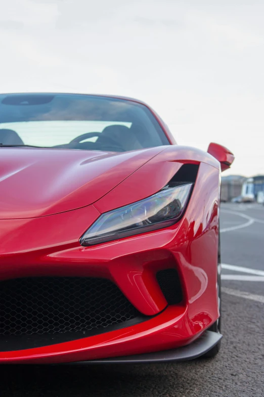 the front end of a red sports car parked in a parking lot