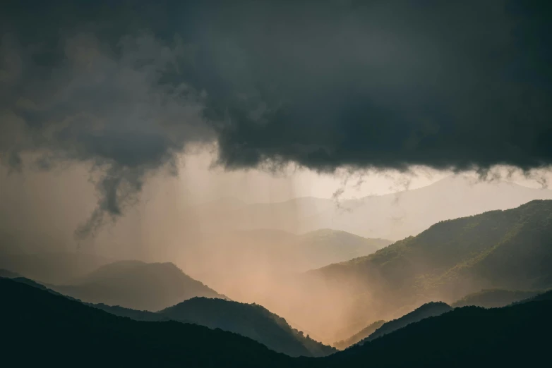 the storm clouds loom over the rolling hills