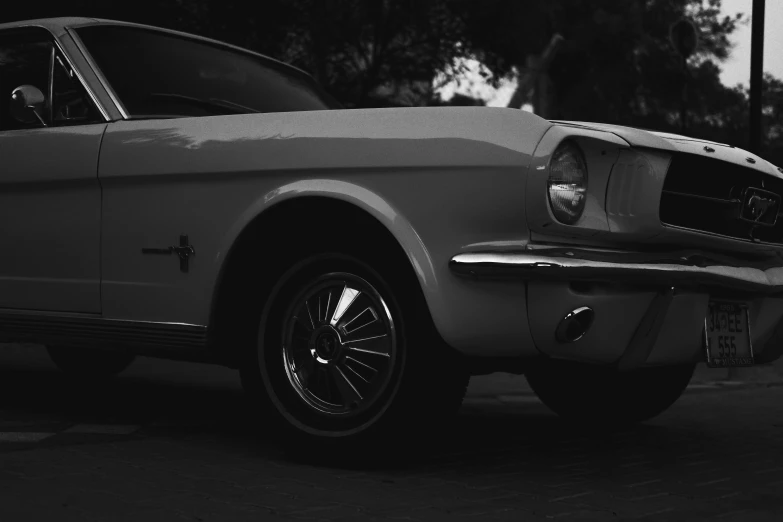 a white mustang is parked in the street