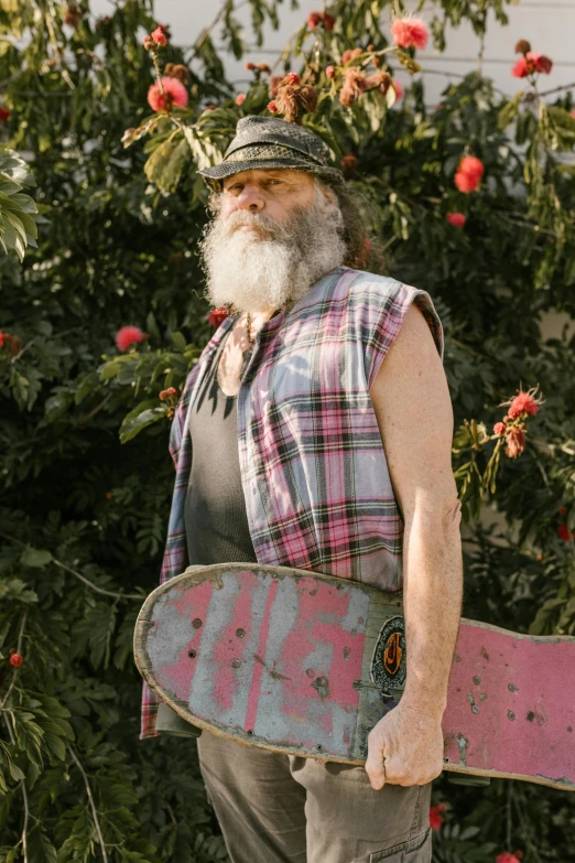 an old man with a beard carrying a skateboard