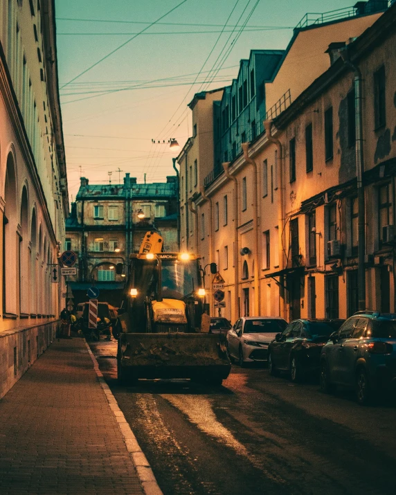 a city street is shown at twilight with buildings