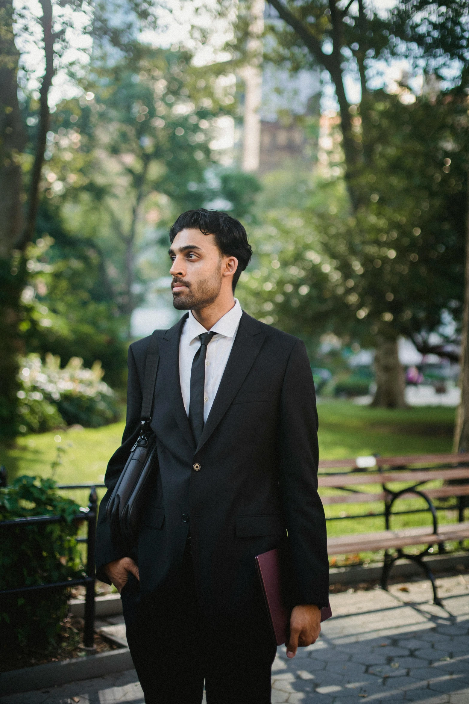 a man in a suit walking in the park