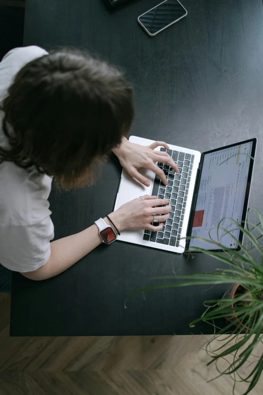 a woman sitting at a table with a laptop computer