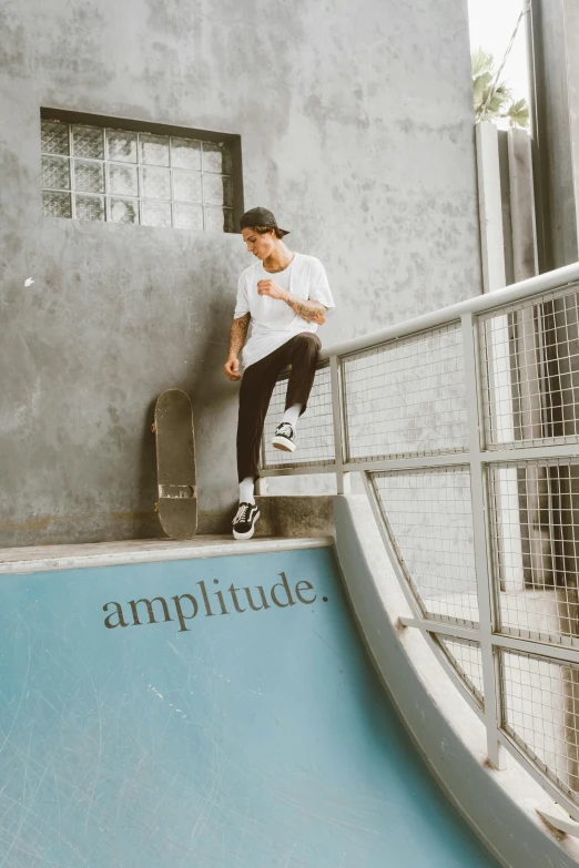 skateboarder leaning against the wall in front of an above ground swimming pool