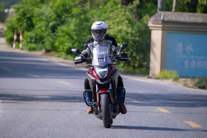 a man on a red and black motorcycle is going down the street