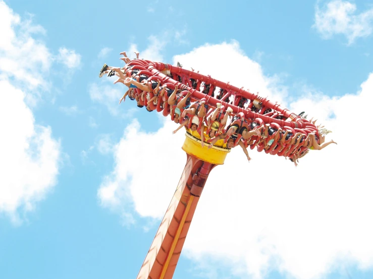 people in a roller coaster ride against a blue sky