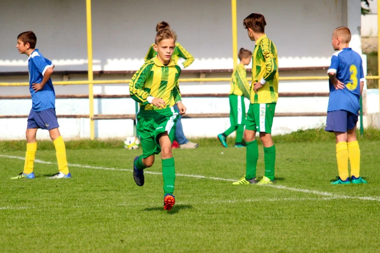 children's soccer playing with ball in front of other s